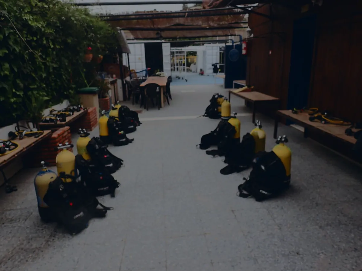 El patio del centro con las botellas amarillas ya montadas sobre los jackets, colocadas en dos filas en el suelo, y los reguladores extendidos sobre bancos de madera.