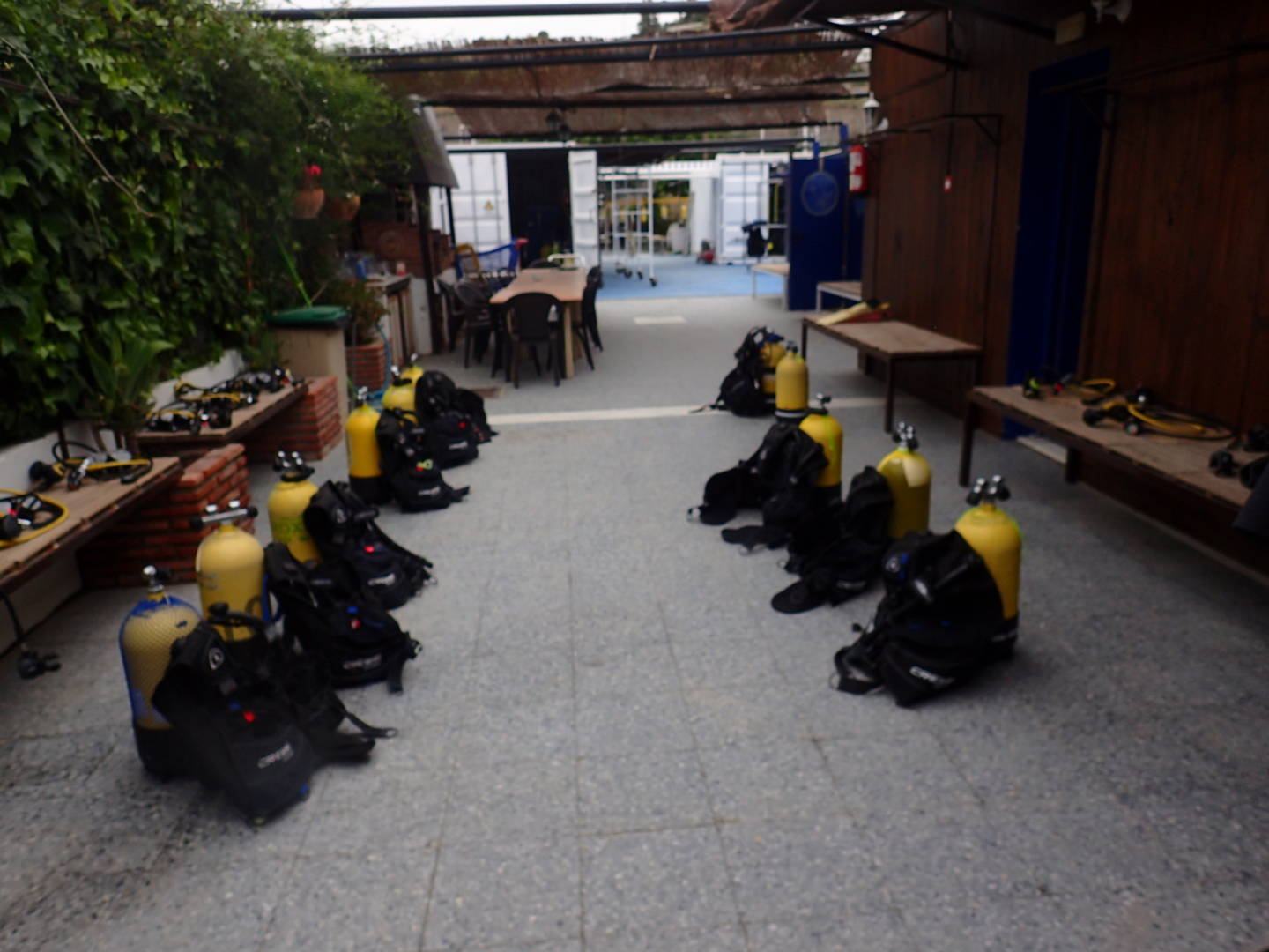 El patio del centro con las botellas amarillas ya montadas sobre los jackets, colocadas en dos filas en el suelo, y los reguladores extendidos sobre bancos de madera.