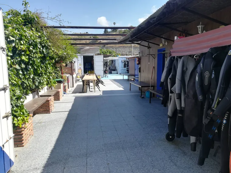 Patio del centro con trajes colgados y bancos de madera